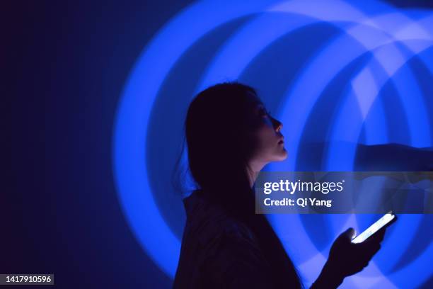 young asian woman using smartphone on the holographic background. metaverse and ai - 3d scanning stock pictures, royalty-free photos & images