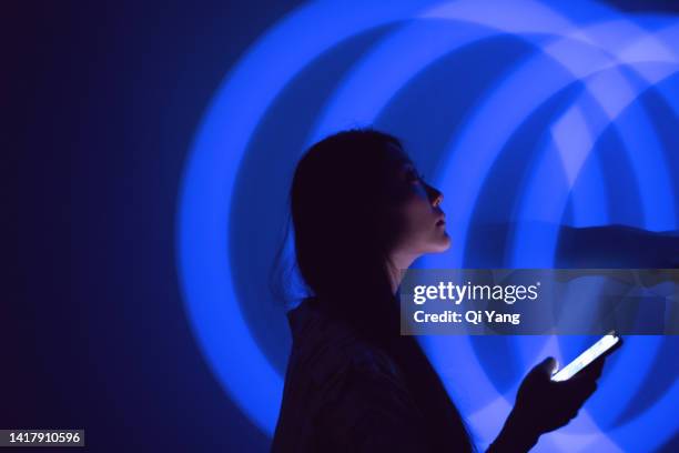young asian woman using smartphone on the holographic background. metaverse and ai - digital transformation concept bildbanksfoton och bilder