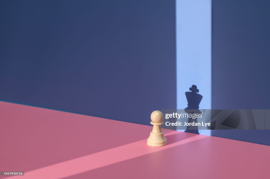 Pawn chess piece with king shadow