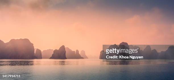 aerial view of sunset and dawn near rock island, halong bay, vietnam, southeast asia. unesco world heritage site. junk boat cruise to ha long bay. - halong bay stockfoto's en -beelden