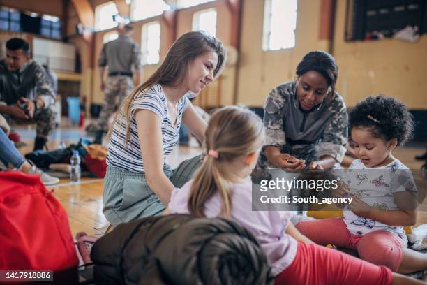 soldiers with civilians after natural disaster - refugee crisis stock pictures, royalty-free photos & images