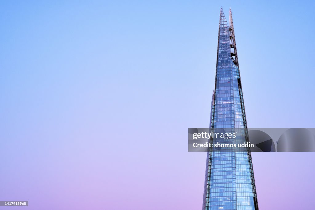 High section of a tall modern glass building at dusk