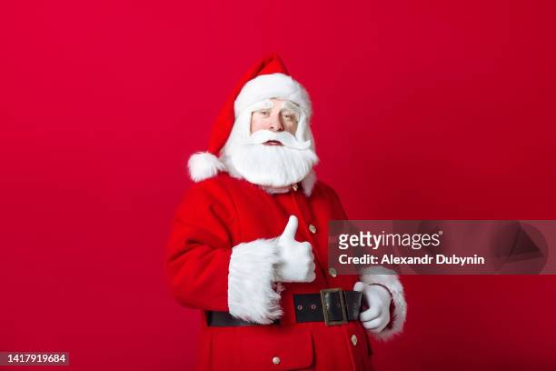 santa claus showing thumbs up gesture on red background - pai natal imagens e fotografias de stock