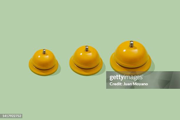 three yellow reception bells in scale - receptiebel stockfoto's en -beelden