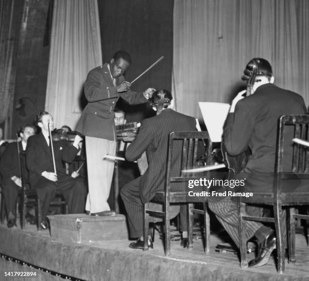 Guyanese conductor, musician, composer and journalist Rudolph Dunbar wearing a United States military War Correspondent's uniform conducts the Berlin...