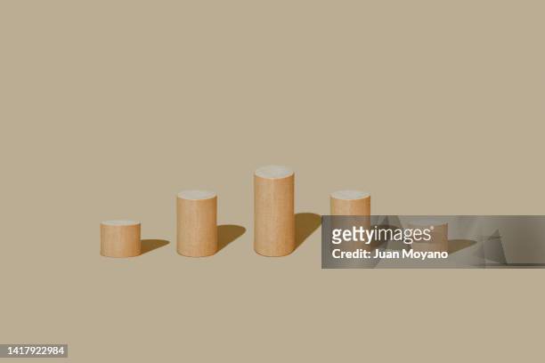 cylindrical wooden building blocks of different lenghts - devaluation stock pictures, royalty-free photos & images