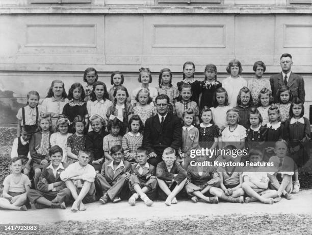 Children of the Lidice village school 2nd form class with their teacher Petřík Zdeněk pose for a class photograph on 4th June 1942 at Lidice in the...