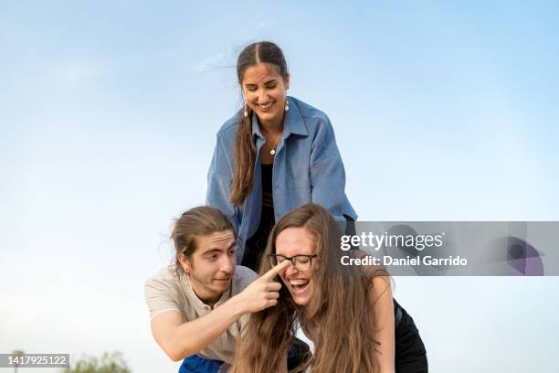 Three Friends Making A Human Pyramid Three Friends Playing Enjoying ...