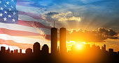 New York skyline silhouette with Twin Towers and USA flag at sunset. 09.11.2001 American Patriot Day banner.