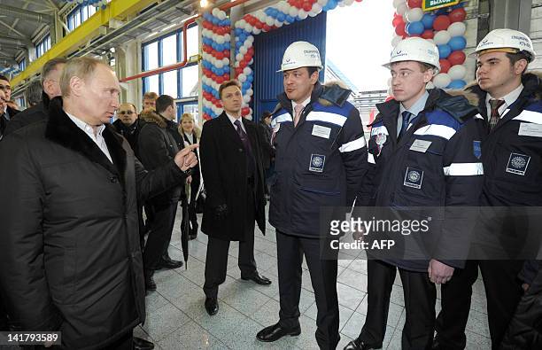 Russia's Prime Minister and President-elect Vladimir Putin speaks with workers as he visits an oil terminal at the Ust-Luga port, the ending point of...