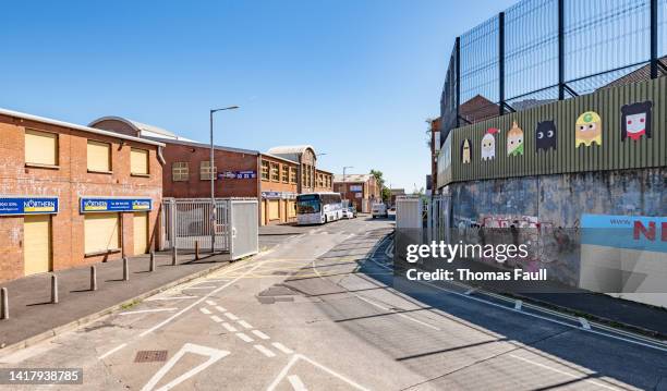 road and gate part of the peace lines that divides belfast - belfast stock pictures, royalty-free photos & images