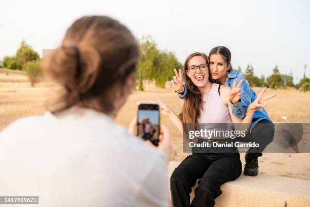 three friends taking photos and selfies, three friends enjoying, living life - hacer foto fotografías e imágenes de stock