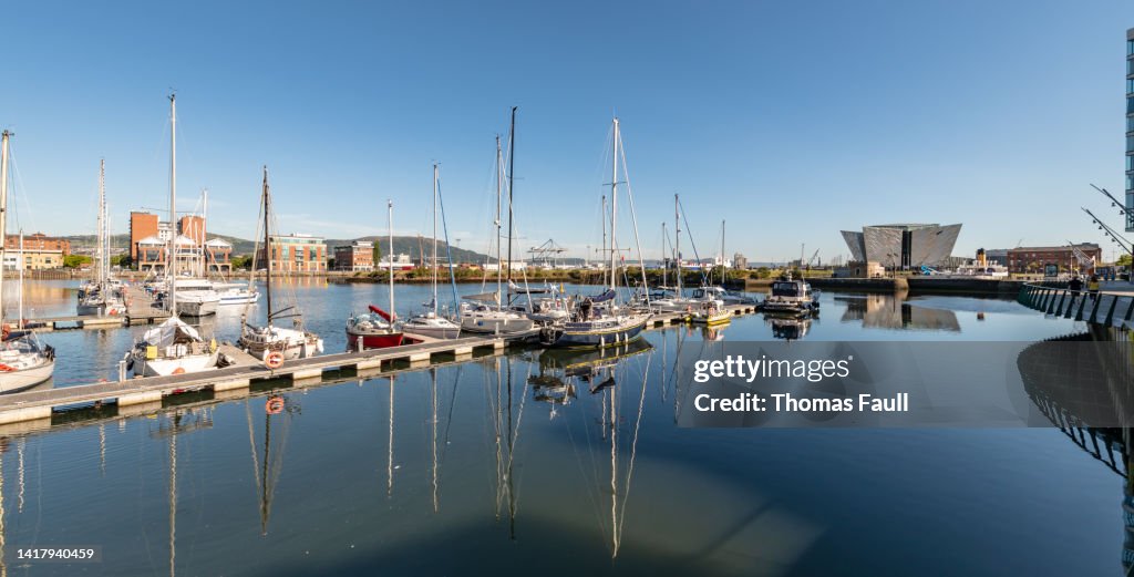 Boats in Belfast harbour with various buildings
