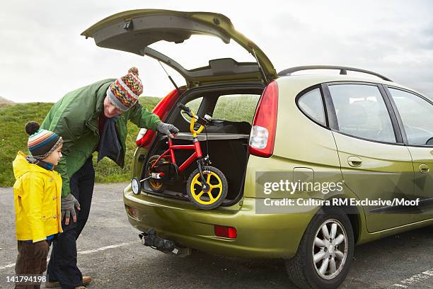 father unloading bicycle from car - training wheels stock pictures, royalty-free photos & images