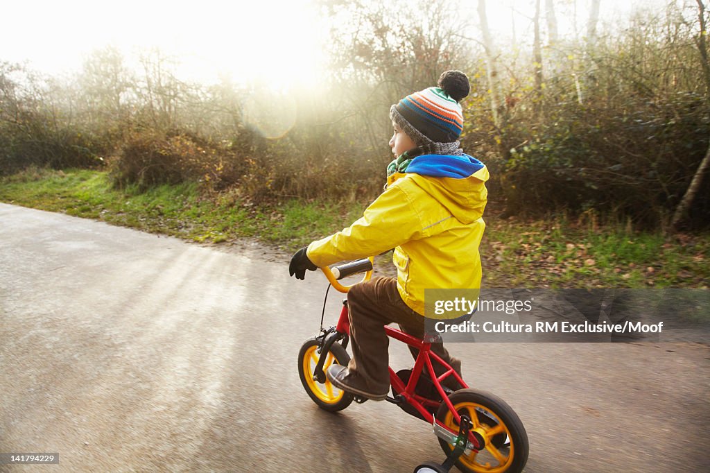 Boy riding bicycle on rural road