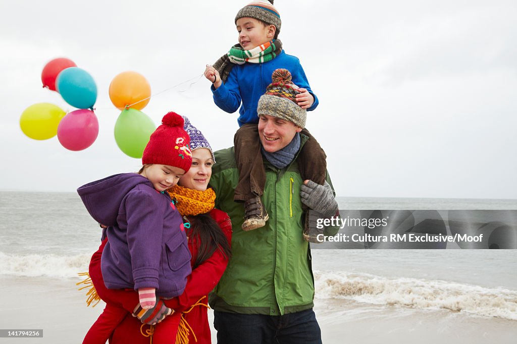 Family bundled up on beach