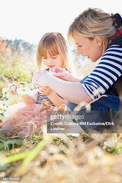 mother and daughter playing with flowers - ketting van madeliefjes stockfoto's en -beelden