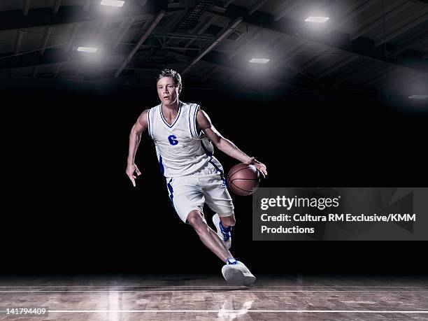 basketball player dribbling on court - dribbling sport fotografías e imágenes de stock