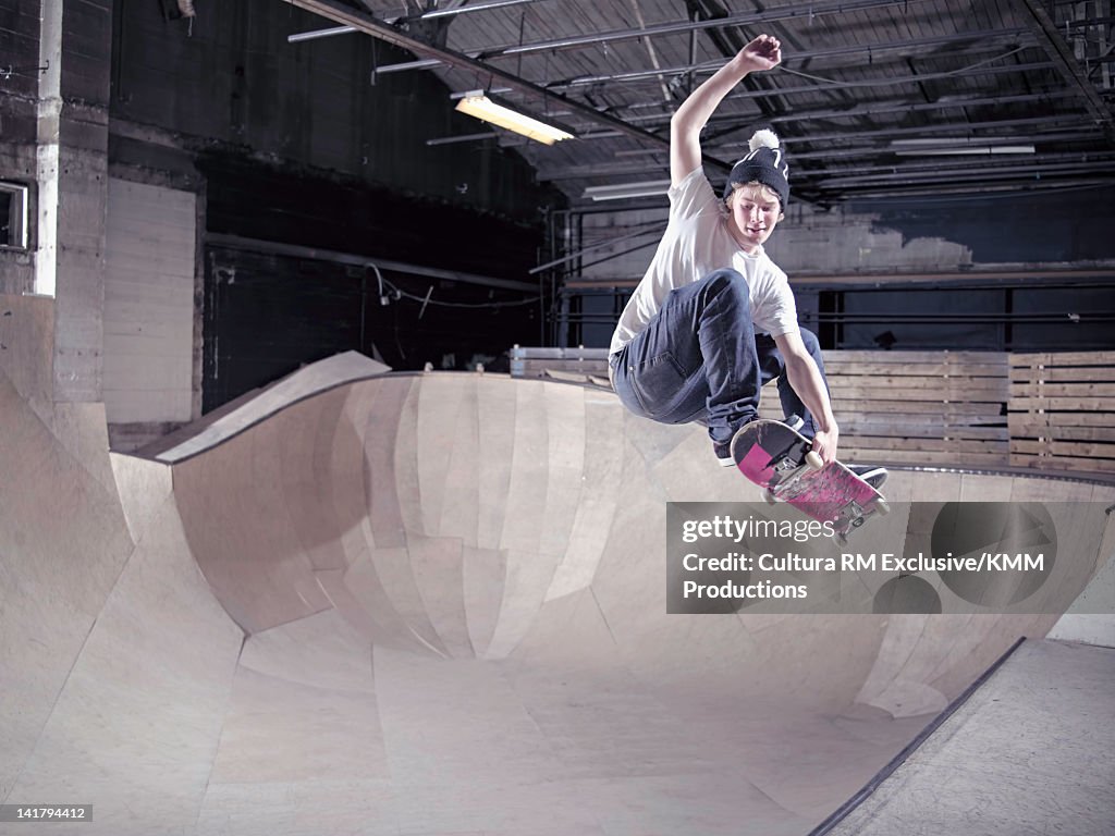 Skateboarder skating on indoor ramp