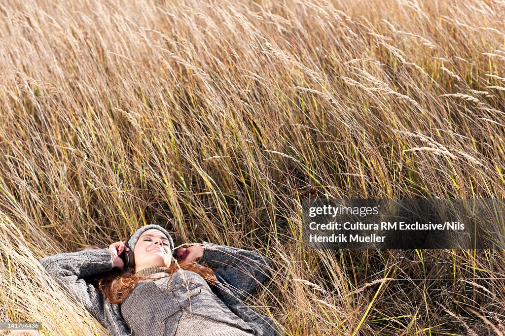 Woman listening to headphones outdoors