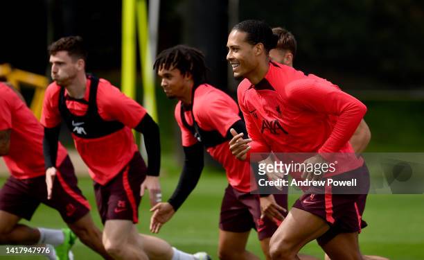 Andy Robertson, Trent Alexander-Arnold and Virgil van Dijk of Liverpool during a training session at AXA Training Centre on August 25, 2022 in...