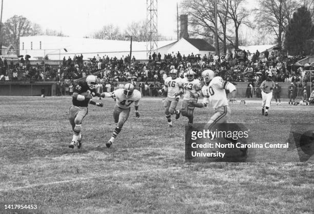 Billy Alsbrooks , North Carolina College halfback, sweeps left end and finds four A&amp;T Aggie defenders blocking his path. Rushing in on the tackle...