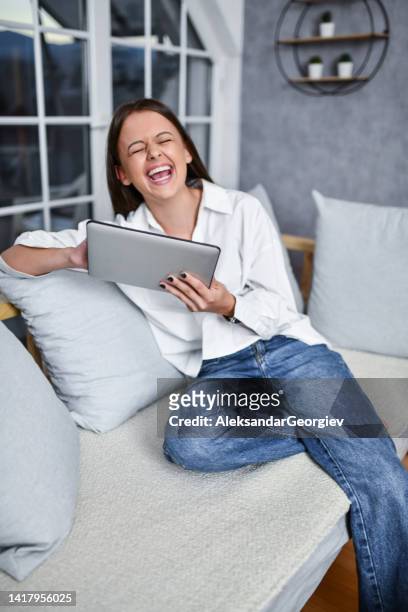smiling female watching funny tv show - woman picking up toys stock pictures, royalty-free photos & images