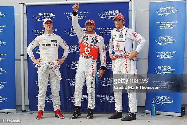 Third placed Michael Schumacher of Germany and Mercedes GP, pole sitter Lewis Hamilton of Great Britain and McLaren and second placed Jenson Button...