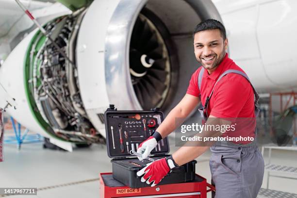 portrait of aircraft mechanic working on engine in an airplane hangar - spare part stock pictures, royalty-free photos & images