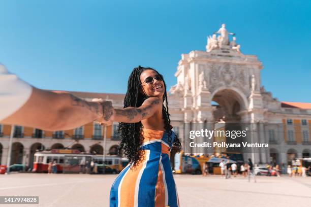 couple holding hands at praça do comércio in lisbon - lissabon stockfoto's en -beelden