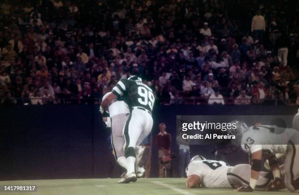Defensive End Mark Gastineau of the New York Jets sacks Quarterback Marc Wilson of the Los Angeles Raiders and recovers a fumble in the game between...