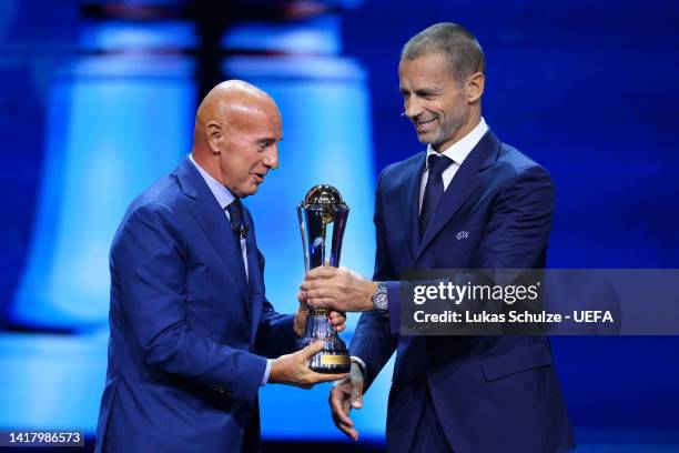 President, Aleksander Ceferin hands Arrigo Sacchi the UEFA President's Award Trophy during the UEFA Champions League 2022/23 Group Stage Draw at...