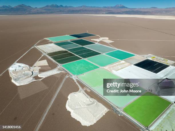 In this aerial view, pools of brine containing lithium carbonate and mounds of salt bi-product stretch through a lithium mine in the Atacama Desert...