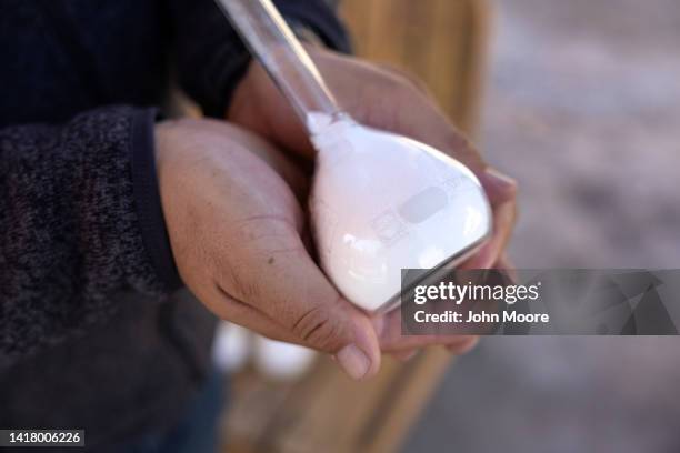 Albemarle Corporation spokesman Marcelo Valdebenito holds a bottle of processed lithium carbonate at a lithium mine on August 24, 2022 in Salar de...