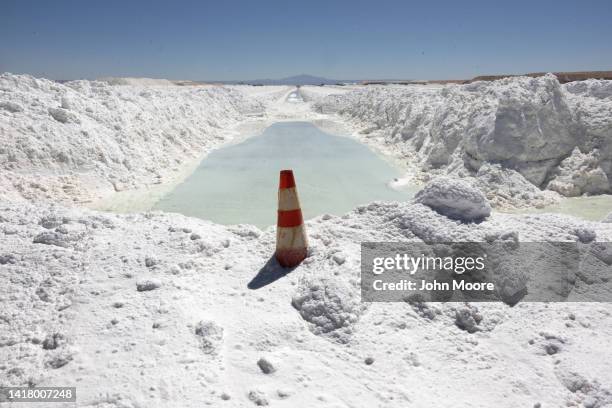 Lithium-rich brine dries in an evaporation pond next to mounds of salt bi-product at a lithium mine in the Atacama Desert on August 24, 2022 in Salar...