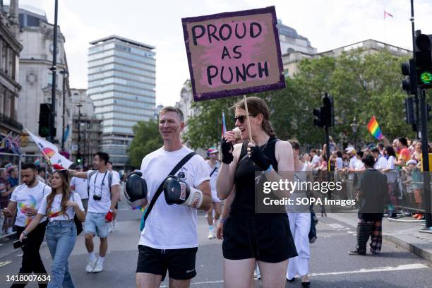 Participants are seen with a placard and boxing gloves during the Pride Parade London 2023. Hundreds of thousands of people participated in the Pride...