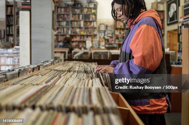 close up shot of woman searching through vinyl records,gqeberha,south africa - plattenladen stock-fotos und bilder