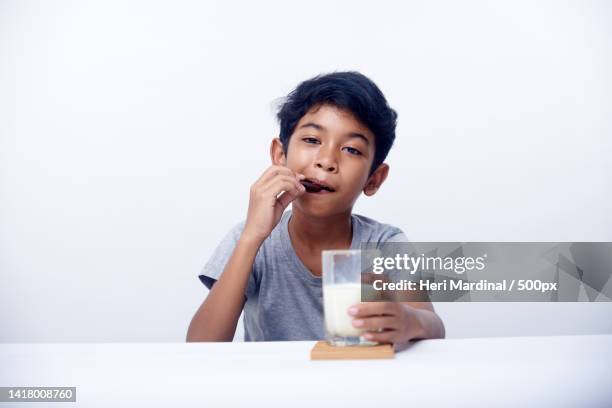 children eat breakfast and drink fresh milk,bali,indonesia - heri mardinal stock pictures, royalty-free photos & images