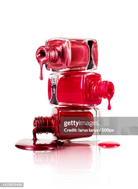 close-up of red wine bottle against white background - red nail polish stockfoto's en -beelden