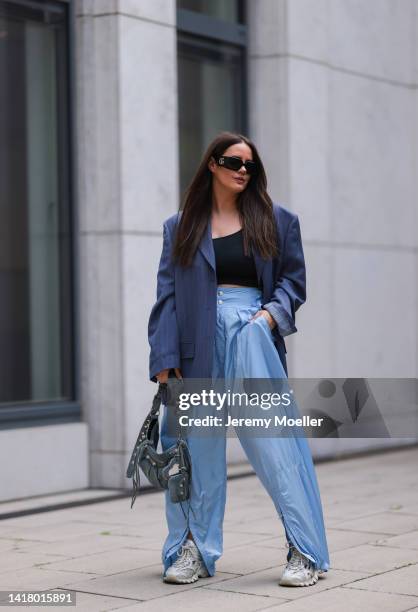 Julia Zwingenberg wearing Gucci black bold statement shades, Acne Studios navy blue oversized blazer, black cropped top, baby blue wide leg pants,...