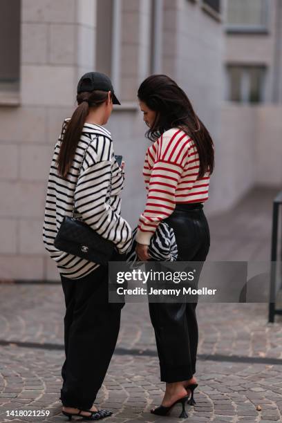 Julia Zwingenberg wearing Balenciaga black logo cap, striped black and beige Arket sweater, Chanel medium black leather flap bag, Preach wide leg...