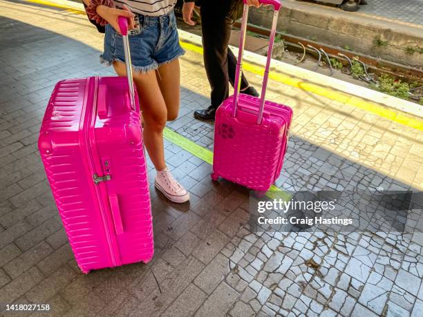 close up of unrecognisable woman traveler with luggage walking through concourse. scene could be airport, train or bus station and used as a concept piece for travel, tourism, adventure, wellbeing and business marketing. - carry on bag imagens e fotografias de stock