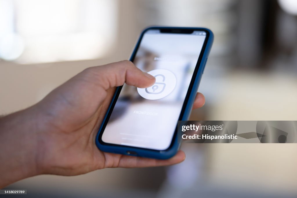 Man locking his house using a home automation app