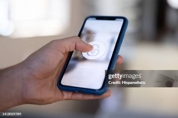 homem trancando sua casa usando um aplicativo de automação residencial - password - fotografias e filmes do acervo