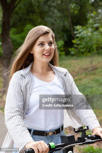 young woman on electric scooter in park - daylight saving time 2021 stock pictures, royalty-free photos & images