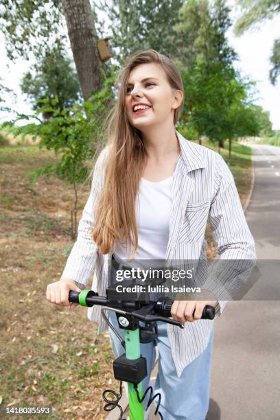 young woman on electric scooter in park - daylight saving time 2021 stock pictures, royalty-free photos & images