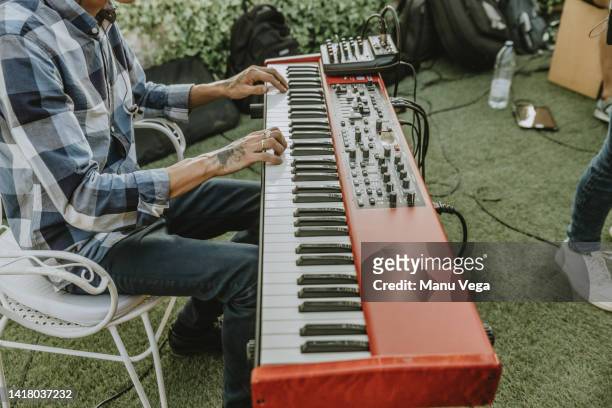 man playing the electric organ during an outdoor performance with his band. - electric piano fotografías e imágenes de stock