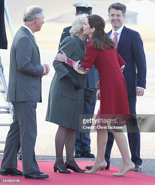 Prince Charles, Prince of Wales and Crown Prince Frederik Of Denmark look on as Camilla, Duchess of Cornwall kisses Princess Mary of Denmark as they...