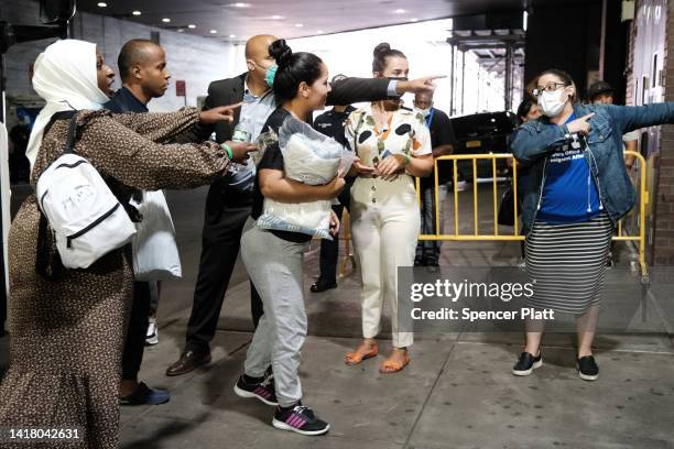 Migrants who crossed the border from Mexico into Texas exit a bus as it arrives into the Port Authority bus station in Manhattan on August 25, 2022...
