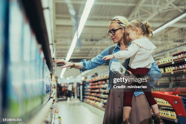 mama und tochter beim gemeinsamen einkaufen im supermarkt - mom buying milk stock-fotos und bilder